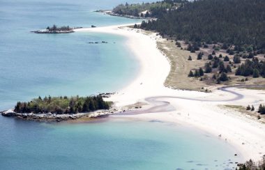 Aerial view of Carters Beach on a sunny day. The beach is on the right and the water is on the left.