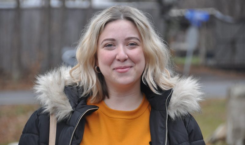 A headshot of Catherine Emond-Provencher wearing a black parka and orange shirt.