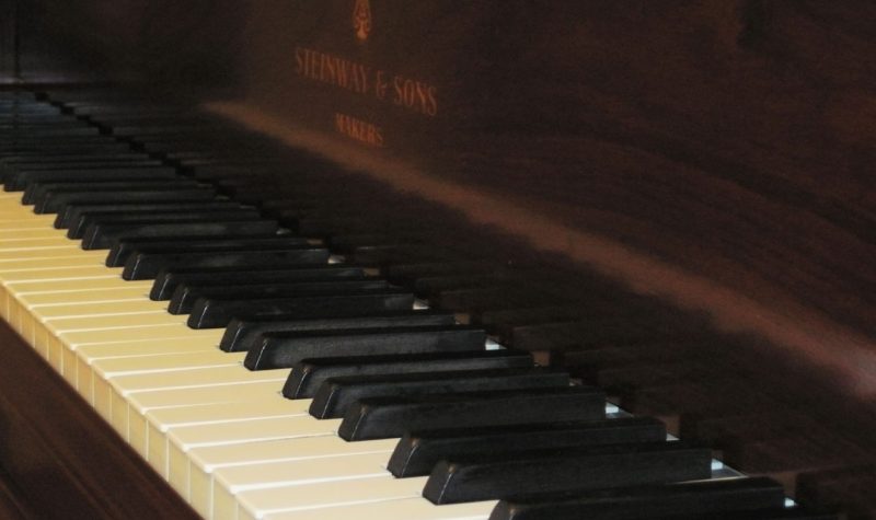 A picture of keys on a dark wooden piano
