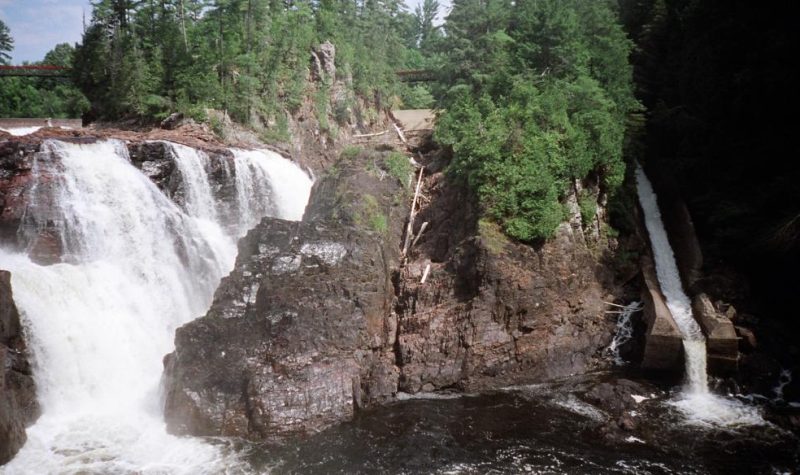 A photo of the Chutes Coulonge, a large waterfall with a timber slide on the right.