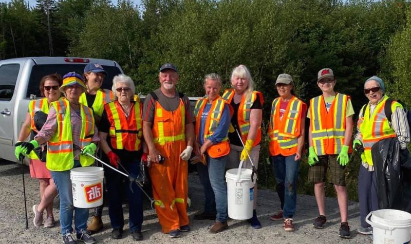 A photo of volunteer clean up crew by the side of the road.