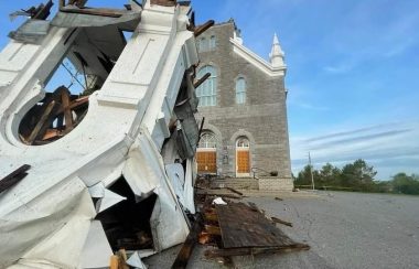 Le clocher tombé et endommagé est sur le pavé du stationnement devant l’église.