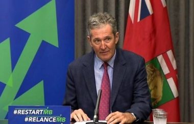 Brian Pallister assit devant son bureau