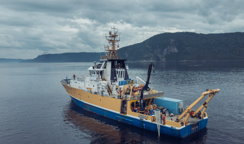 Un navire de recherche bleu, jaune et blanc sur le fleuve Saint-Laurent