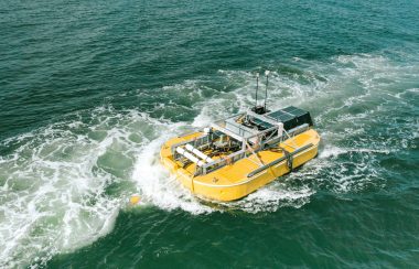 A yellow device on a boat cruises along green waters. Iceberg-class desalination unit