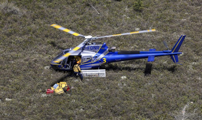 A helicopter is unloaded in a field