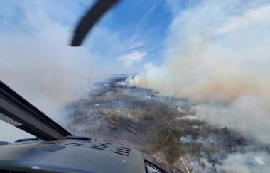 Smoke from a forest fire can be seen from a helicopter above the fire