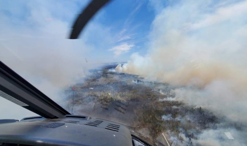 Smoke from a forest fire can be seen from a helicopter above the fire