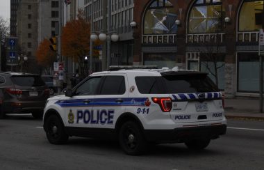 An Ottawa Police Service vehicle is seen idling in downtown traffic on a cloudy day.