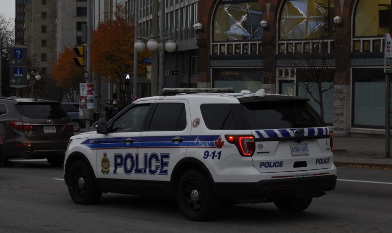An Ottawa Police Service vehicle is seen idling in downtown traffic on a cloudy day.
