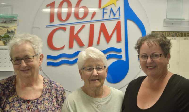 Trois dames en avant du logo de Radio CKJM