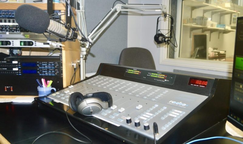Une console, un micro et des écouteurs dans un studio de radio.