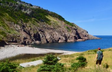 Un jeune homme marchant dans un sentier près de la mer.