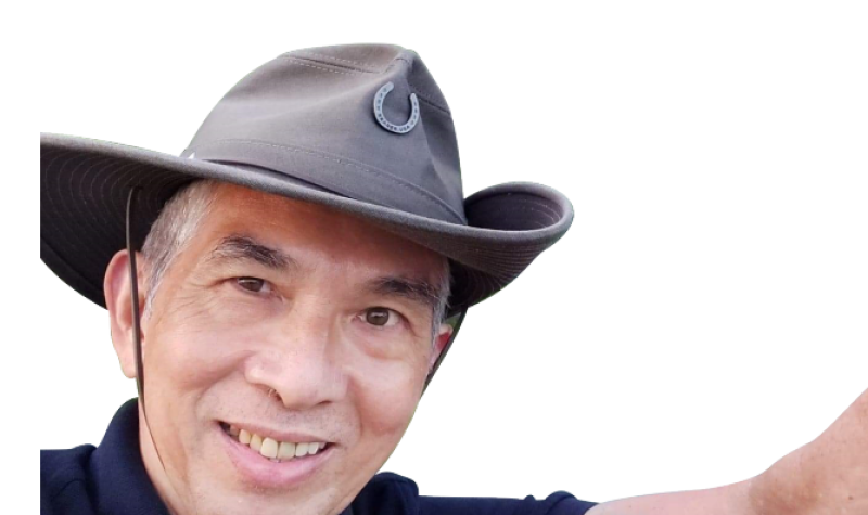 A person is smiling while wearing a camping hat.