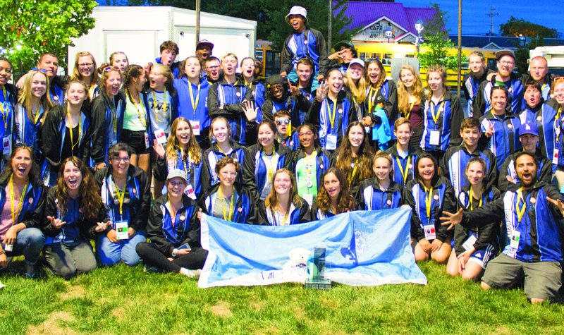 Un groupe de jeunes vêtus de dossards bleus, médaille au cou