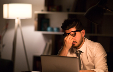 Un hombre frente al computador que se muestra cansado