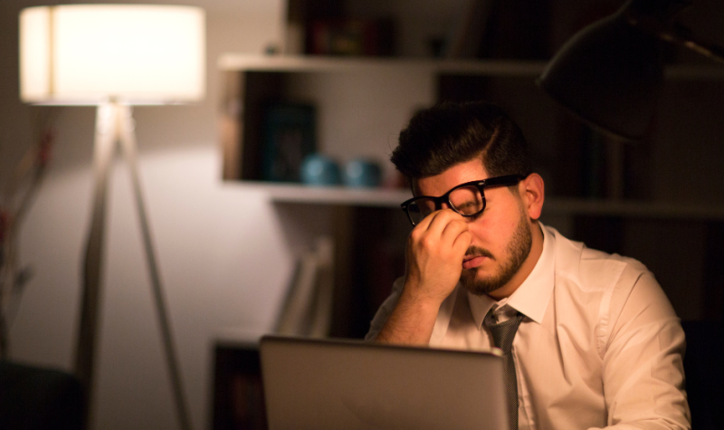 Un hombre frente al computador que se muestra cansado