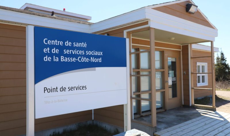 Un panneau mentionnant un point de service du CISSS de la Côte-Nord aux côtés de l'entrée d'un petit bâtiment d'un étage.