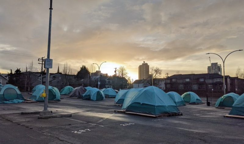 Numerous blue tents are seen in downtown Victoria at sundown