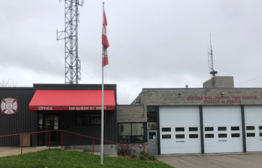 A cloudy day at the detachment of Centre Wellington Fire Rescue Services department in Fergus. A flag sits on a grass lawn.