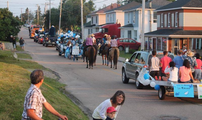 Des gens dans une parade de rue avec des voitures et des chevaux