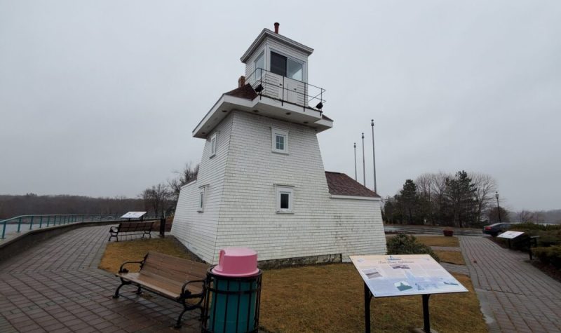The historic white Fort Point Lighthouse is seen on an overcast day in Nova Scotia