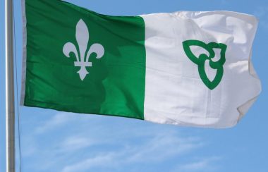 Drapeau franco-ontarien vert et blanc dans le ciel bleu