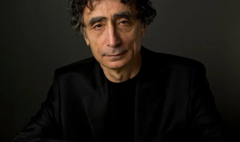 A man wearing dark clothing looking straight ahead