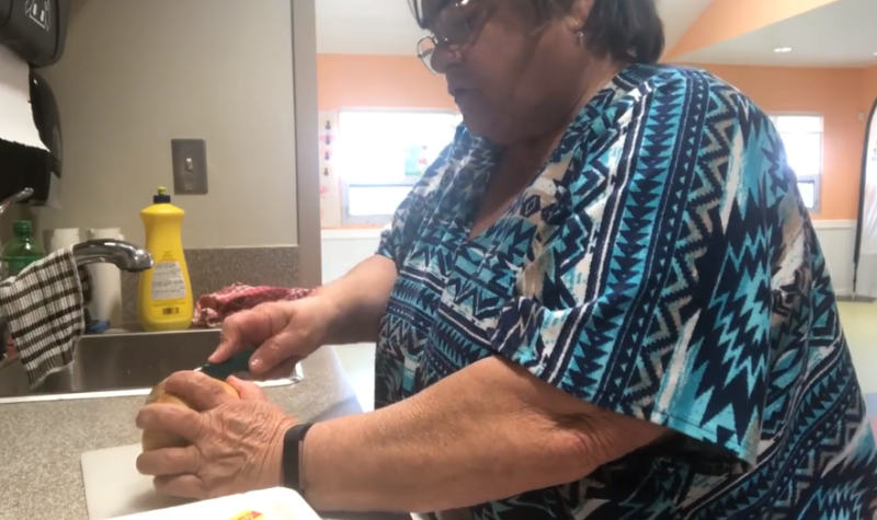 Deanna Cadman chops a potato on a counter.