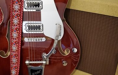 An electric guitar rests against an amplifier