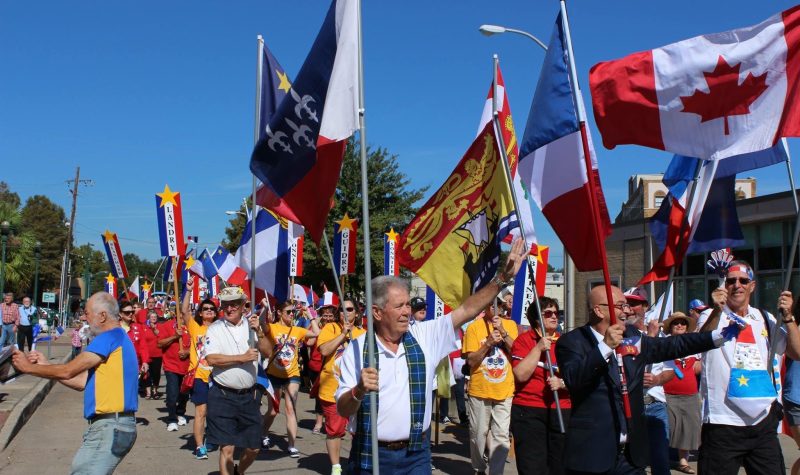 Défilé de nombreuses personnes portant des drapeaux Acadiens, Canadiens, ou encore du Nouveau-Brunswick. (Photo : Site du Grand Réveil Acadien)