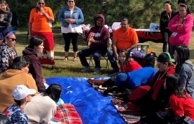 Volunteers standing and sitting after setting up hands games event