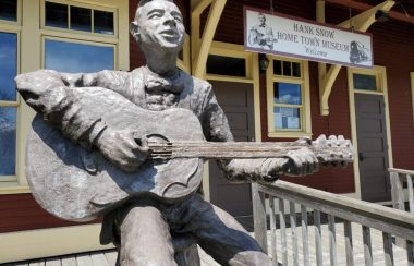 A statue of Hank Snow playing a guitar outside Hank Snow Museum, Liverpool NS.