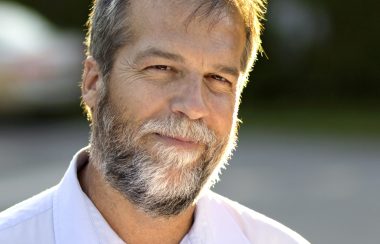Photo shows author Phil Gurski, a grey-haired man with a beard and mustache wearing a white shirt.