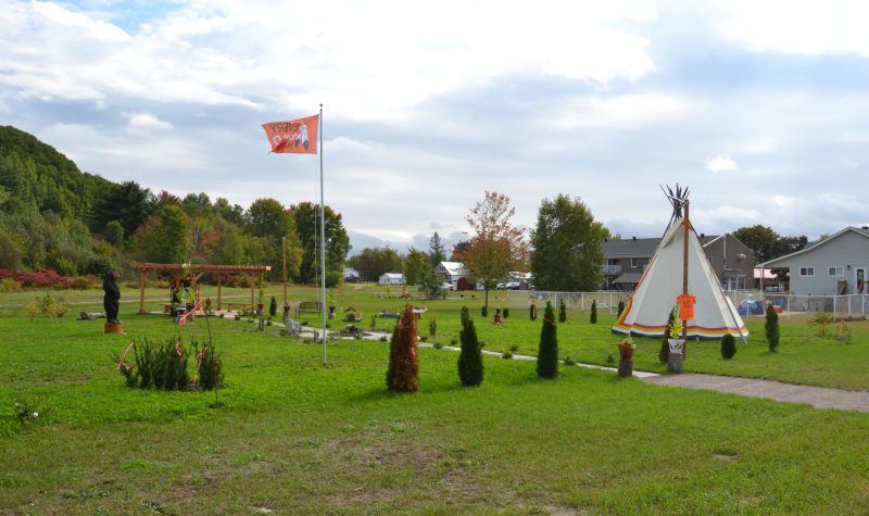 A photo of the Pontiac Native Community's healing garden in Mansfield, featuring a teepee, orange flag and plants arranged in a circle.