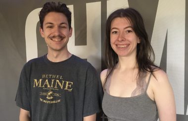 A man and woman standing smiling in front of a wall that reads CHMA