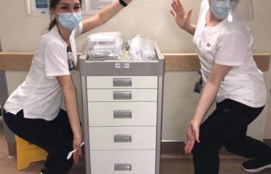 Two nurses display a new gynaecological cart donated by the Queens General Hospital Auxiliary