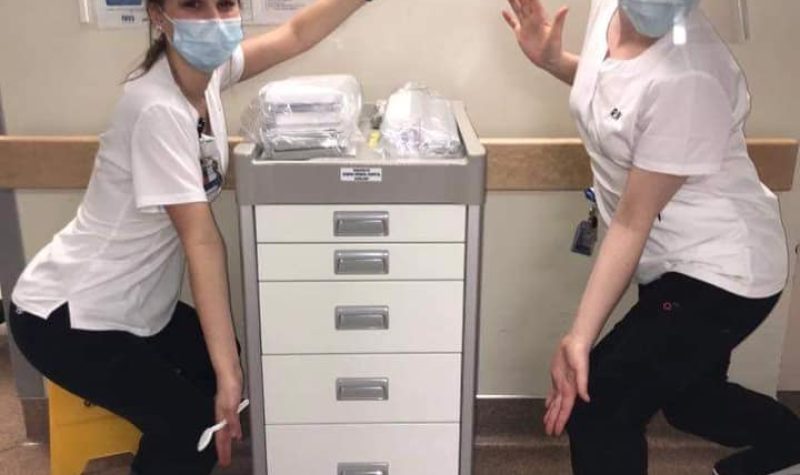 Two nurses display a new gynaecological cart donated by the Queens General Hospital Auxiliary