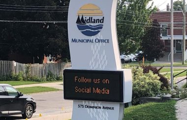 On peut voir le panneau numérique de l'hôtel de ville de Midland situé sur Dominion Avenue. Le panneau est blanc et imite la forme d'une vague verticale. Sur le panneau on peut voir le symbole de la ville de Midland et sur la partie numérique on invite la population à suivre la ville sur les média sociaux.