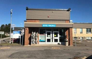 Entrée de l'Hôpital de les Escoumins avec asphalte devant et ciel bleu dégagé