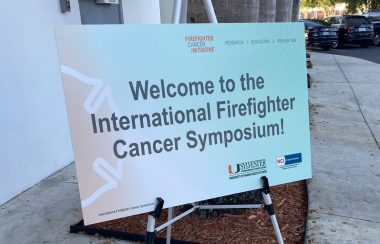 An orange and green poster that says 'Welcome to the International Cancer Firefighter Symposium.
