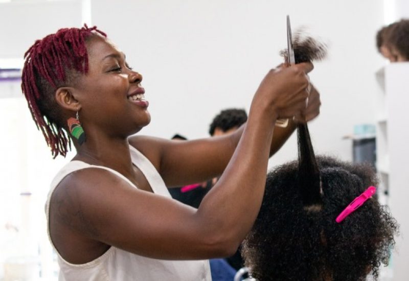 A woman styling hair inside of a salon in Ottawa