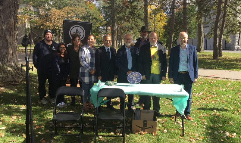 People stand outdoors behind a table