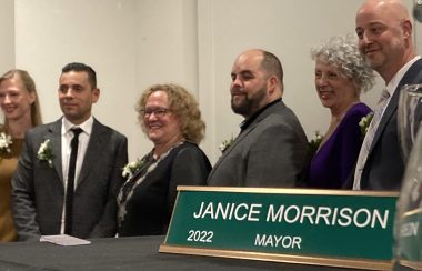 A group of Nelson city council posing for this photo on November 8. The group is standing indoors against a white wall, with mayor janice Morrison in the middle