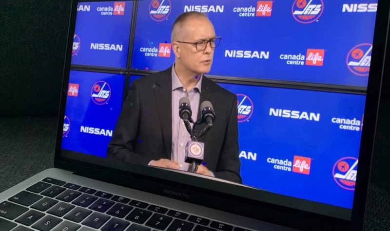 Un ordinateur portable joue la conférence de presse montrant Paul Maurice devant un micro avec un arrière-plan bleu couvert de logos des Jets