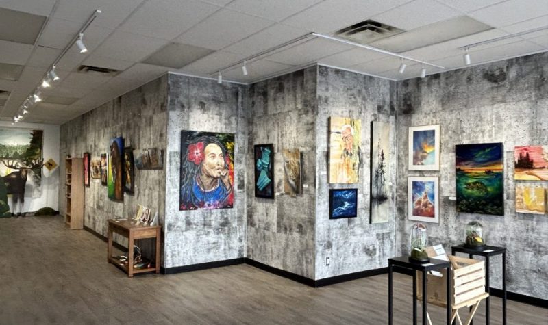 Galerie d'art avec des œuvres , des toiles d'artistes fixées au mur.