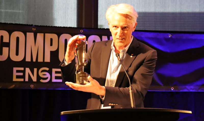 Image shows Allan Reid holding JUNO Award at event on stage