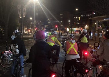 Cyclistes de dos avec casques dans la ville à la tombée de la nuit