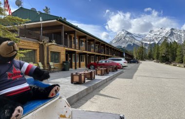 Vue sur le bâtiment d'accueil du David Thompson Resort, en bois, style chalet, durant un jour ensoleillé.