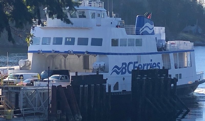 A BC Ferries vessel sits at an island dock.